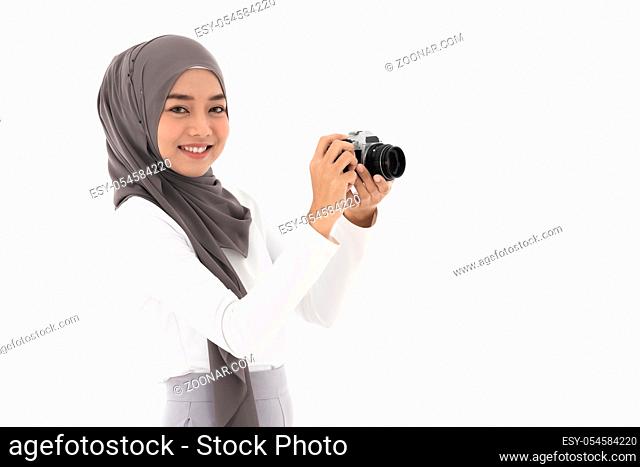 Portrait of happy young adult asian muslim fenale tourist and photographer holding a camera and smiling. Studio shot of woman isolated on white background