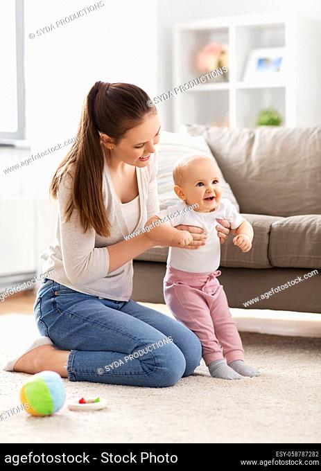 happy mother playing with little baby at home