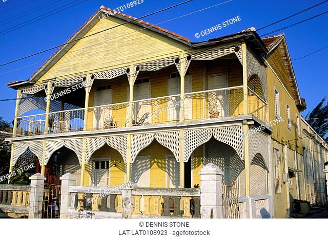 Historic buildings of town. Old French colonial house. Verandah, porch. Balustrade. White and yellow paint