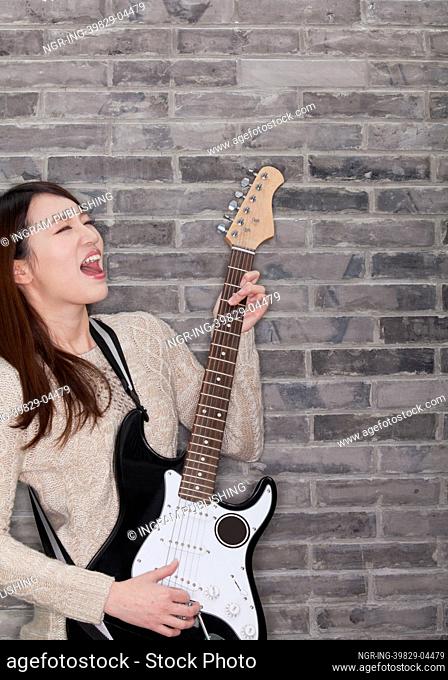 Young Woman Playing a Electric Guitar