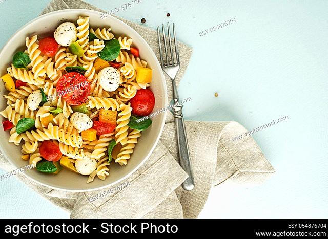 Pasta salad with mozzarella cheese and vegetables. Healthy pasta meal