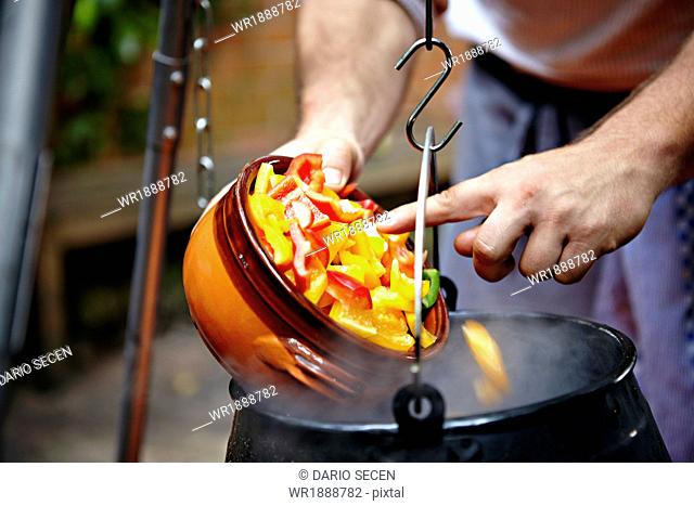 Person Adding Vegetable In Cooking Pot