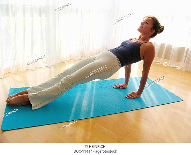 To improve Pilates - Excercise according to Joseph Pilates - figure through gentle Bodystyling - Leg Pull Up - initial situation before complete leg is lifted -...