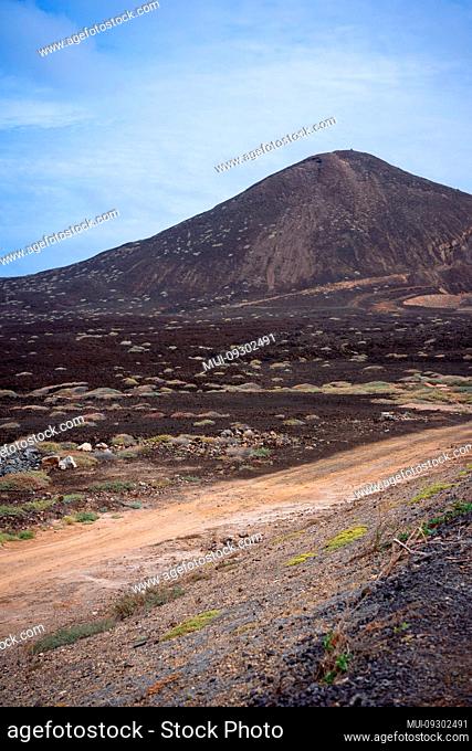 Desolates road over a surreal marslike landscape with majestic volcano creater in the distance. Sao Vicente Cape Verde
