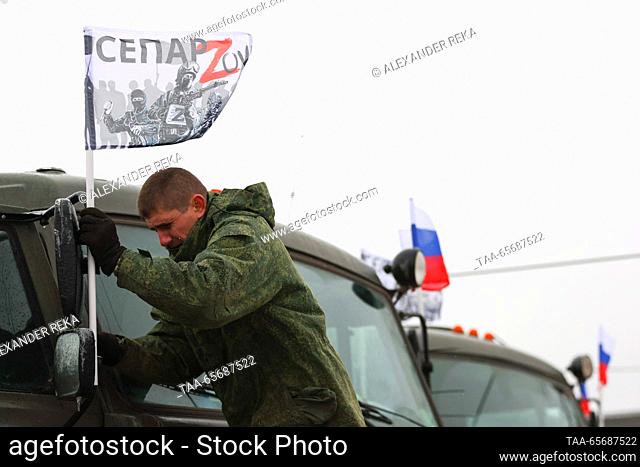 RUSSIA, LUGANSK - DECEMBER 12, 2023: A man attaches a SEPAR ZOV flag to a truck as the volunteers collect more than 20 pieces of special equipment and other...