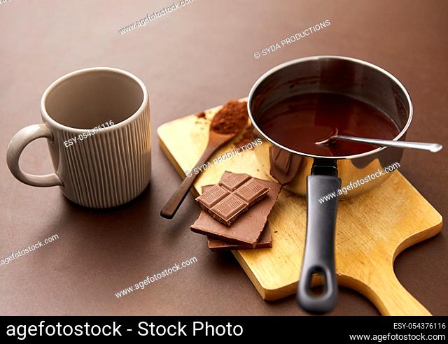 pot with hot chocolate, mug and cocoa powder
