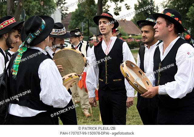 A group of men from Italy participates in the parade of the so-called 'folklore avalanche' (German: Folklorelawine) in the Spreewald region town Luebbenau