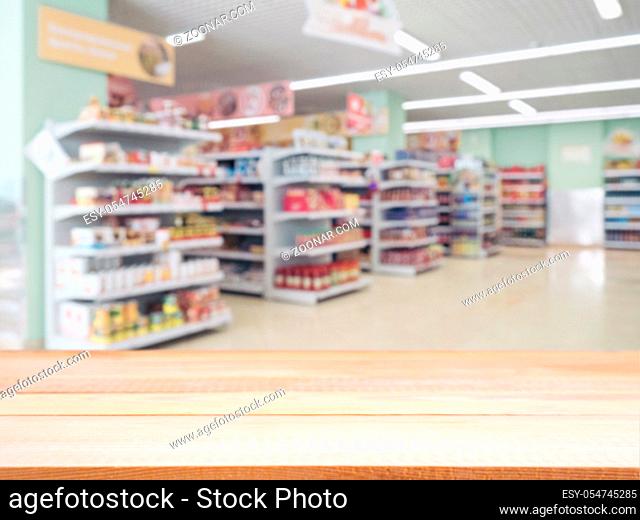 Light wooden board empty table in front of blurred background. Perspective light wood over blur in supermarket - can be used for display or montage your...