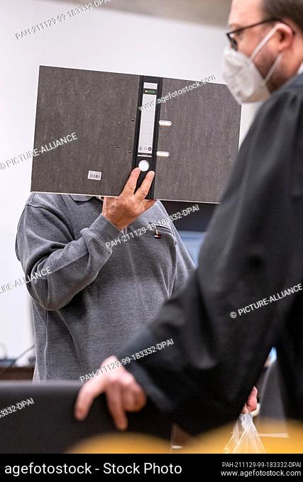 29 November 2021, Bavaria, Nuremberg: A man (l) accused of murder arrives at the start of the trial in the courtroom at the Criminal Justice Centre of the...