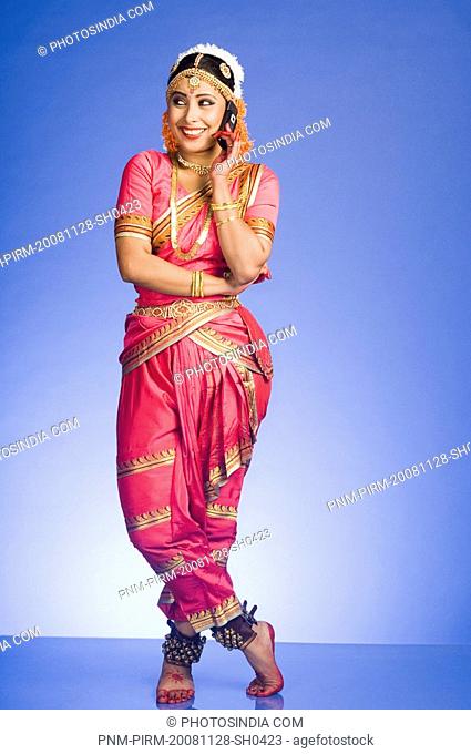 Woman talking on a mobile phone in and performing Bharatnatyam