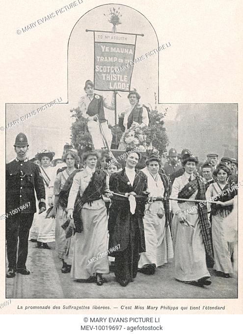 A procession of released suffragettes. Mary Phillipps holds the flag