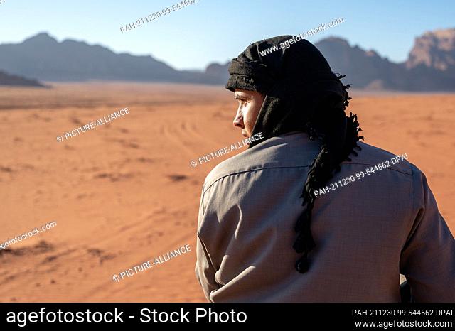 26 November 2021, Jordan, Wadi Rum: A Bedouin rides a camel through the Wadi Rum desert. Photo: Sebastian Kahnert/dpa-Zentralbild/dpa