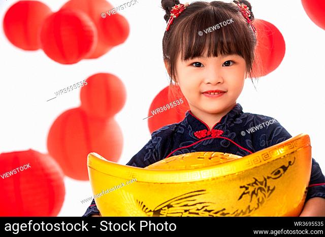Cute little girl holding a gold ingot