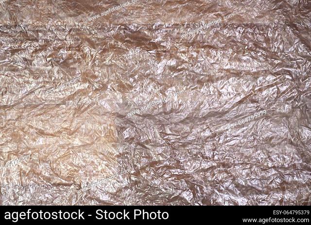 Texture of white crumpled cellophane surface transparent on sunlight. Concept of materials for packaging, product protection against damage