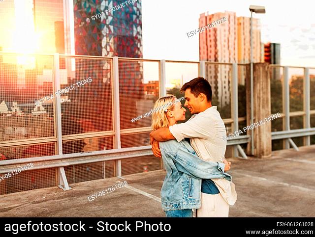 happy young couple on roof top city parking