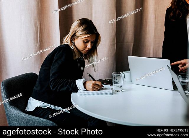Woman in office taking notes