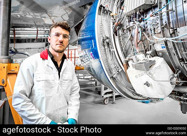 Portrait of young male worker in airplane hangar