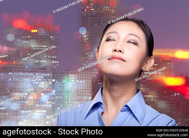 Portrait of young smiling businesswoman, cityscape of Beijing, eyes closed