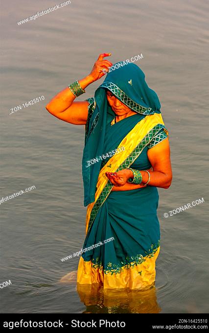 Unidentified Indian women pray and devote for Chhath Puja festival on Ganges river side in Varanasi, India