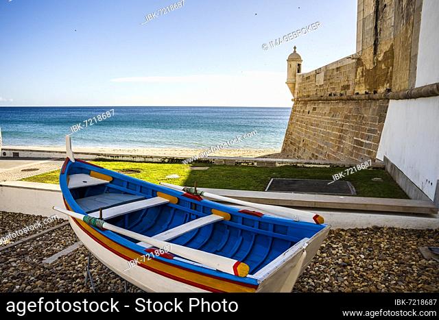 The wooden traditional boat and Saint James Fortress on the beach of Sesimbra, Lisbon Metropolitan Area, Portugal, Europe