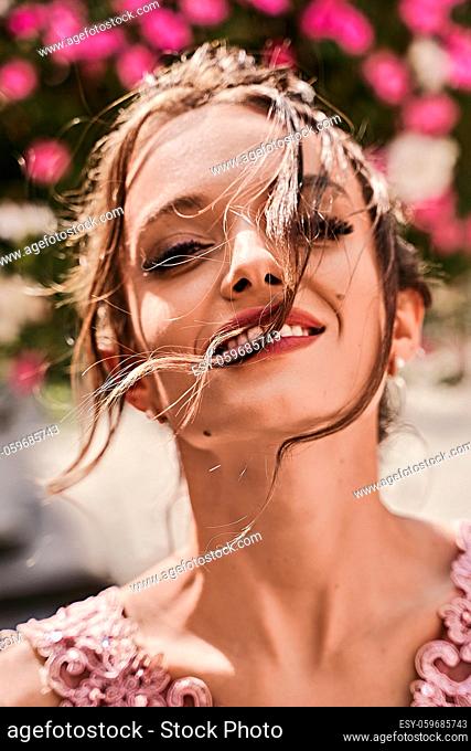 Portrait of a beautiful bridesmaid girl with hair waving in the wind on sunny summer day