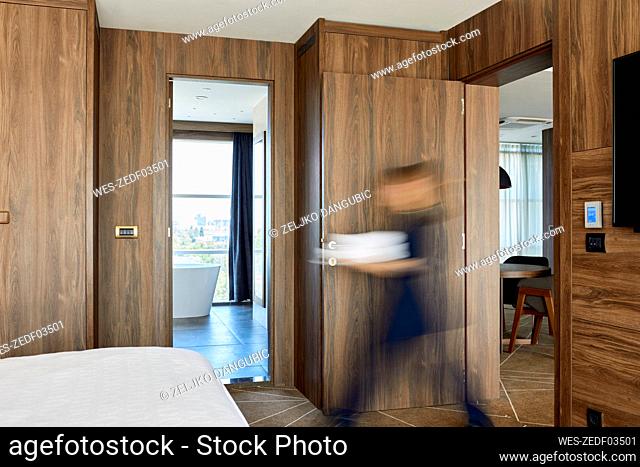 Blurred motion of chambermaid walking on hotel room