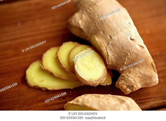 ethno science, culinary, diet, eco food and objects concept - close up of ginger root on wooden table