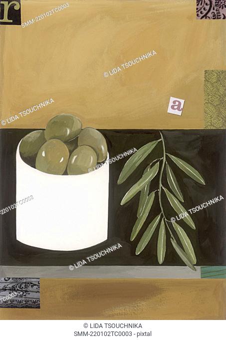 A bowl of green olives with an olive branch