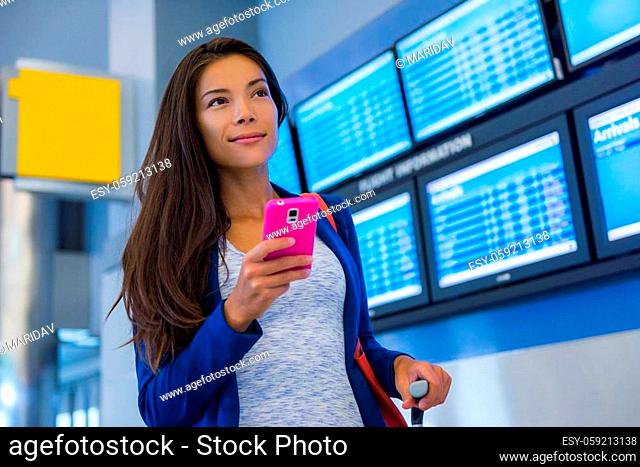 Travel woman using smartphone at airport. Young asian traveler checking boarding time with mobile phone app in terminal or train station
