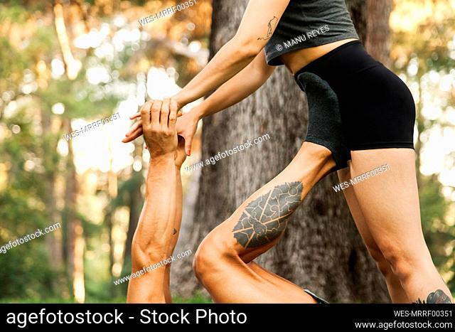 Male and female athletes practicing acroyoga in park