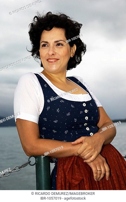 Woman wearing Ausseer traditional costume in front of a lake