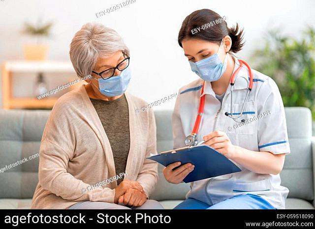 Doctor and senior woman wearing facemasks during coronavirus and flu outbreak. Virus protection. COVID-2019. Taking on masks