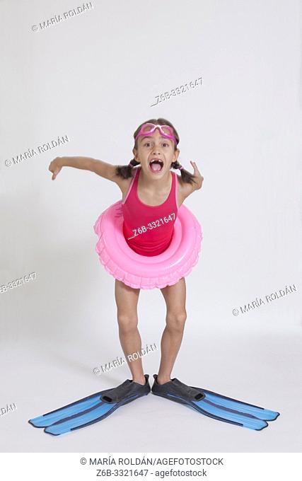 Studio full length portrait of a girl in swimsuit with a swim ring and flippers