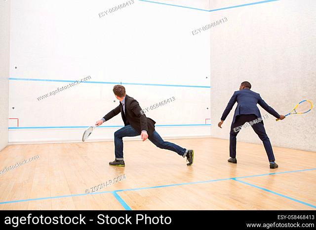 Business meeting of two businessmen playing squash. Warming up of two handsome men before real match in squash