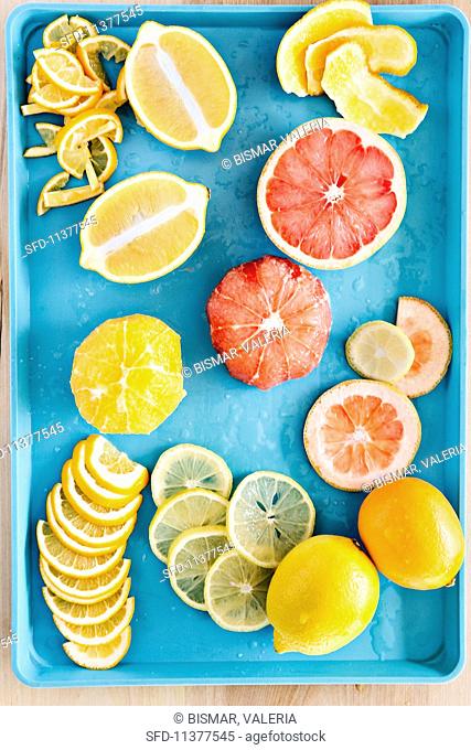 An arrangement of freshly cut lemons, Meyer lemons and grapefruits on a turquoise tray