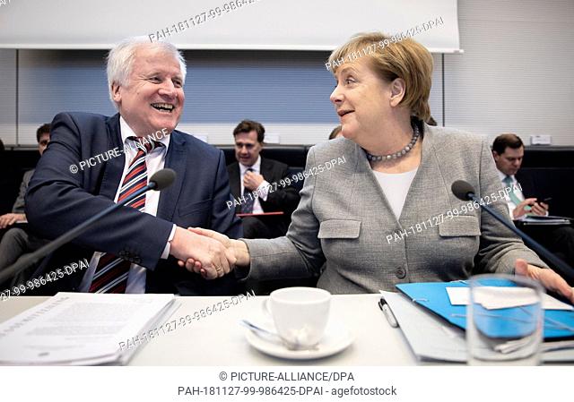 27 November 2018, Berlin: Horst Seehofer (CSU), Federal Minister of the Interior, Building and Home Affairs, and Chancellor Angela Merkel (CDU) participate in...