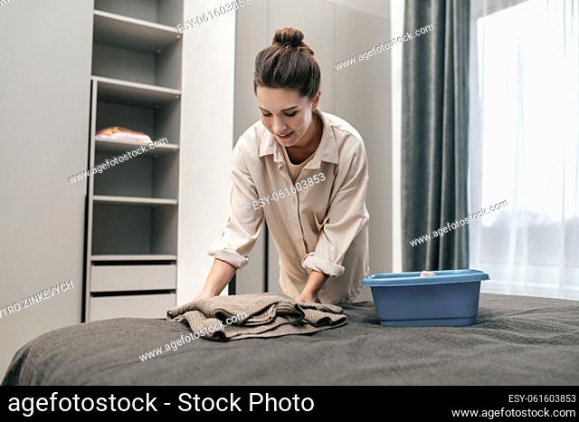 At home. A young woman doing housework and looking busy
