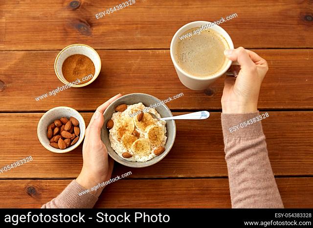hands with oatmeal breakfast and cup of coffee