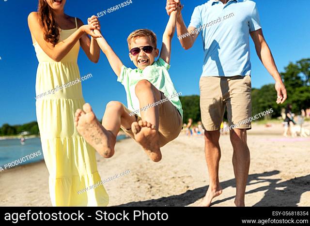 happy family walking along summer beach
