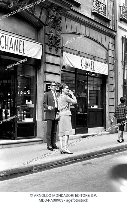 Irish actor Peter O'Toole and his wife, Welsh actress Sian Phillips, in front of a Chanel shop. France, October 1969