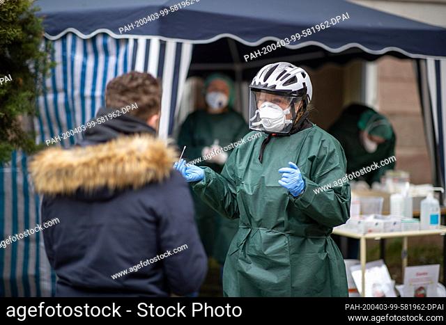 03 April 2020, Bavaria, Nuremberg: An employee of the public health department talks to a visitor in a Corona test centre