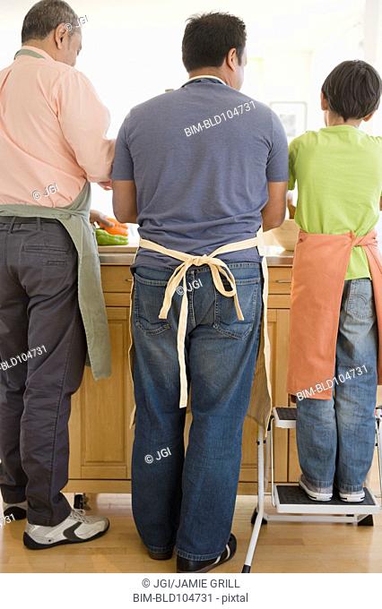 Hispanic grandfather, father and son washing dishes