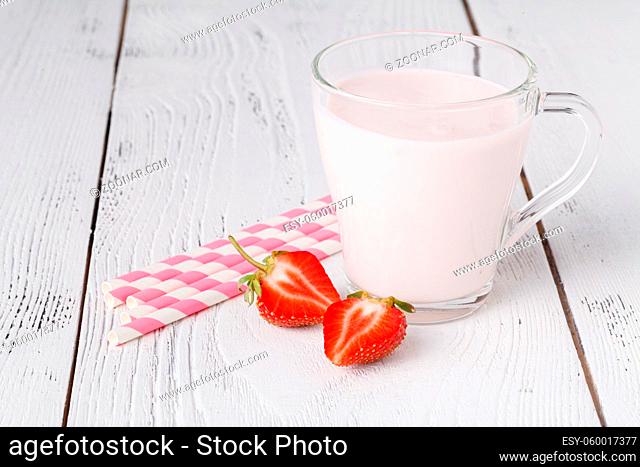 Strawberries and milk drink on white wooden table