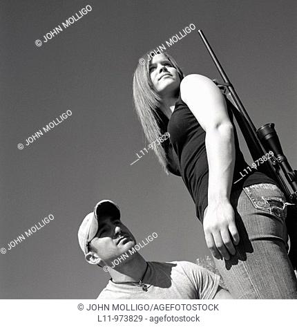 Man and woman with rifle; rural