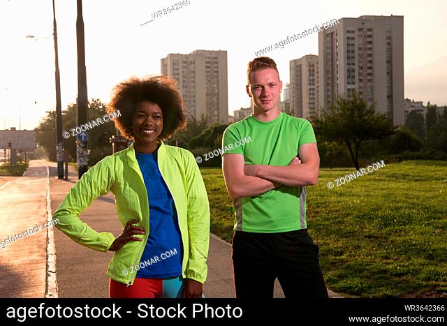 portrait of a young African American beautiful woman and a young man jogging in the city