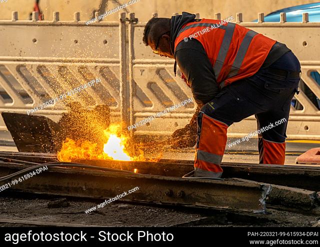 21 March 2022, Bavaria, Munich: A man cuts the exposed streetcar rails near the Gasteig with a welding torch. The entire bridge system between the Deutsches...
