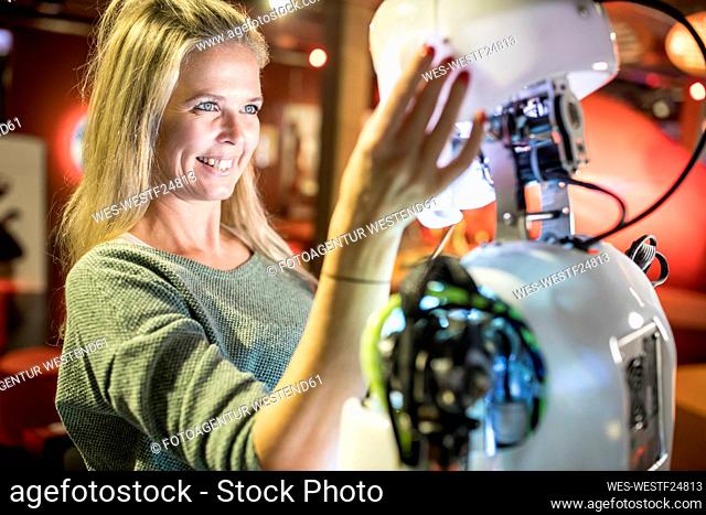Happy technician looking at human robot at workshop