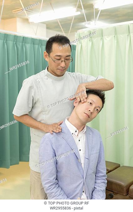 Doctor Manipulating the Head and Neck of A Man