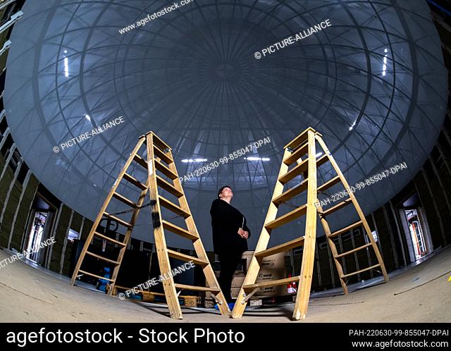 29 June 2022, Saxony-Anhalt, Halle (Saale): Katrin Keym from the Halle/Saale Planetarium takes a look inside the dome of the future planetarium