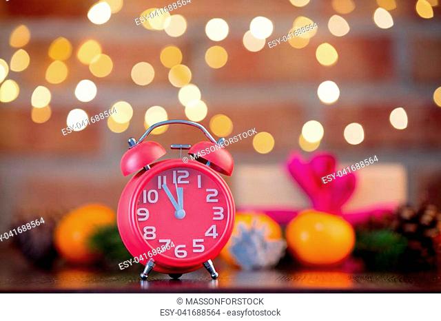 alarm clock on background with fairy lights in bokeh. Christmas Holiday season
